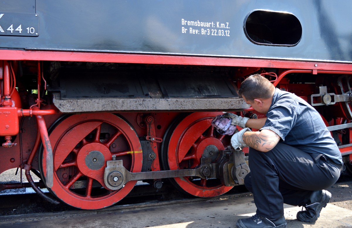 Damit die Lok schön glänzt wird sie immer wieder vom Dreck befreit. Hier tut dies der Lokführer an der 99 4011-5 am 02.08.2015 im BW Putbus.