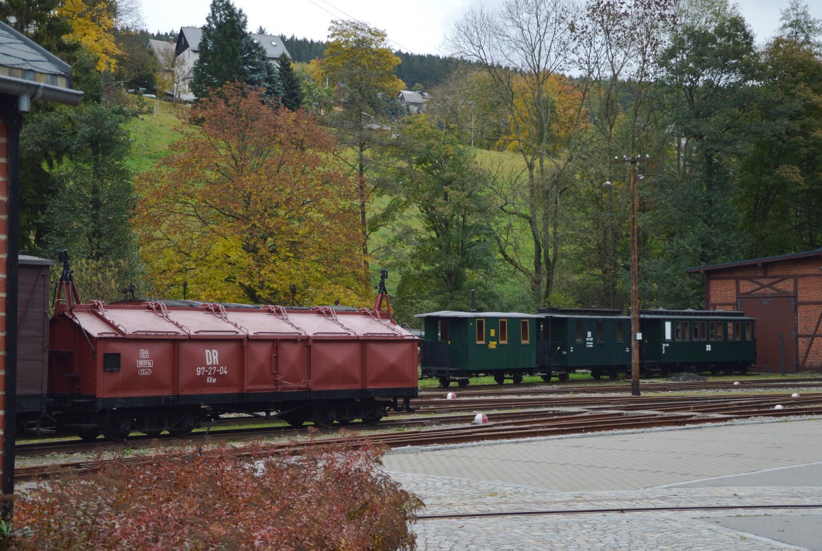 Der KKw 97-27-04 (links) und drei grüne Personenwagen am Lokschuppen am 23.10.2015 in Oberittersgrün.