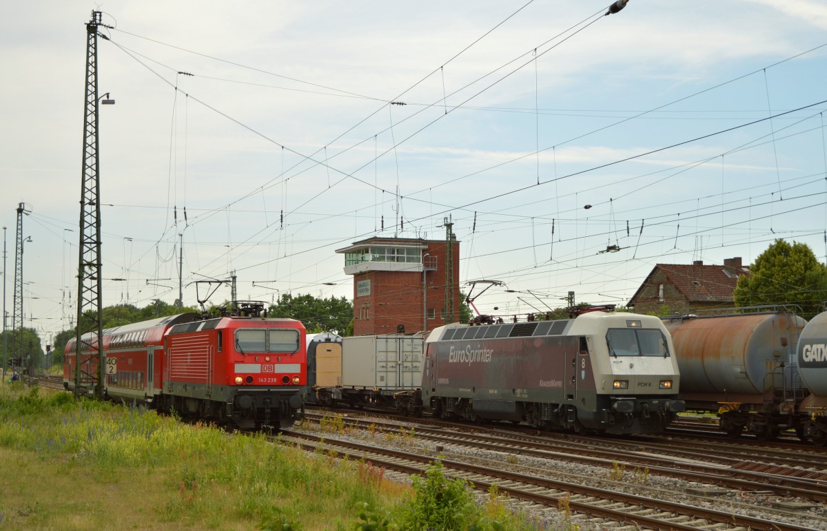 Drei Züge auf einem Bild in Darmstadt Kranichstein am 08.05.2015. Links die RB 75 mit der Lok 143 238 bespannt. In der Mitte eine Wagenüberführung durch die PCW 8 und Rechts ein Güterzug in Richtung Darmstadt.