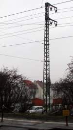 Ein Oberleitungsmast mit dem Km Schild 26,6 und die Kette zum Bahnsteig 2 auf einem Bild.
Aufgenommen in Weiterstadt am 14.Dez.2013