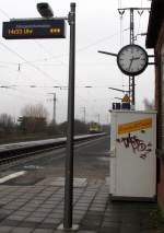 Bahnhofsuhr,Fahrgastinformation und eine Diesellok auf einem Bild.