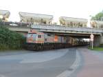 Der HVLE OrangeTiger am 14.08.2015 mit der zweiten Fuhre auf dem Weg zum Rügendamm und unterquert dabei noch seine eigenen Waggons. 