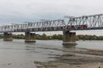 Ein Personenzug gezogen von einer E-Lok überquert die Eisenbahnbrücke über den Ob in Nowosibirsk am 13.